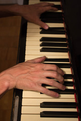 Close up of young boy hands, playing piano. vintage piano
