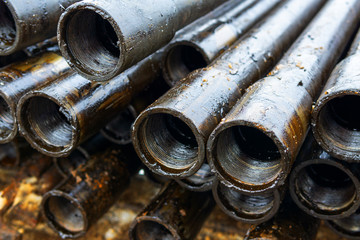Offshore Industry oil and gas production petroleum pipeline. Downhole drilling rig. Laying the pipe on the deck. View of the shell of drill pipes laid in courtyard of the oil and gas warehouse.