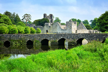 Medieval Desmond Castle, Ireland with old stone bridge, Adare, County Limerick