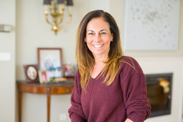 Beautiful middle age woman smiling at home