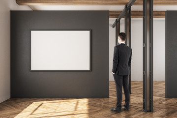 Businessman in warehouse with poster