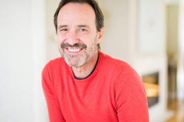 Obraz premium Handsome middle age man smiling looking at the camera at home