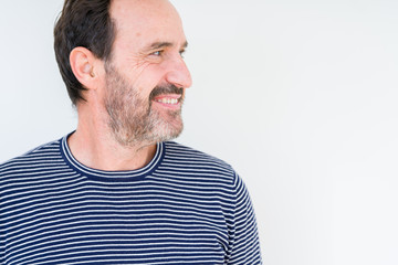 Obraz premium Handsome senior man over isolated background looking away to side with smile on face, natural expression. Laughing confident.