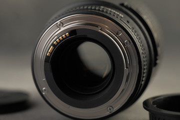 Lens for digital SLR cameras on a gray cement background.