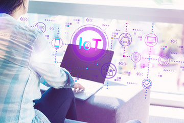 IoT theme with woman using her laptop in her home office