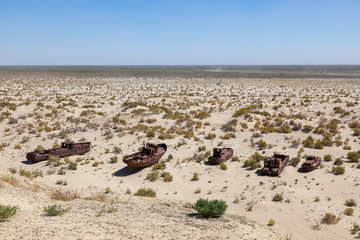 Fototapeta na wymiar Rustic boats on a ship graveyards on a desert around Moynaq, Muynak or Moynoq - Aral sea or Aral lake - Uzbekistan in Central Asia