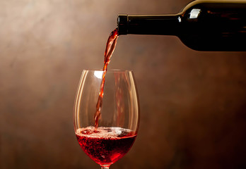 Obraz na płótnie Canvas Pouring red wine into a glass, close-up