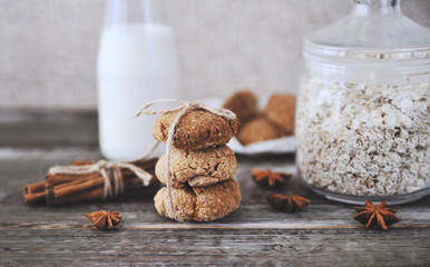 Oat cookies with ingredients on wooden background.