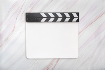 Flat lay of blank white acrylic clapboard on natural marble texture