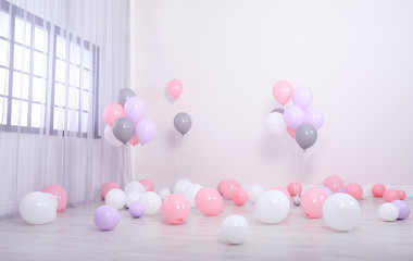 Room decorated with colorful balloons near wall