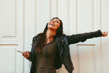 Young woman enjoys music on the street and dancing