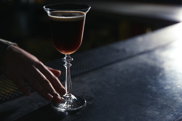 Barman serving espresso martini cocktail at counter, closeup. Space for text