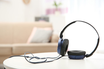Stylish headphones on table indoors. Space for text