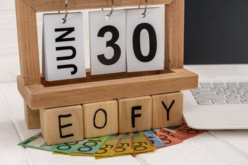 Australian dollars and wooden calendar with cubes EOFY