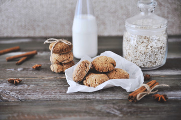 Oat cookies with ingredients on wooden background.