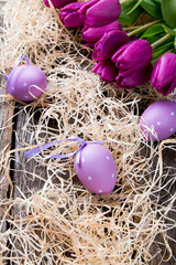 Easter eggs and flower on wooden table. Spring concept on plank.