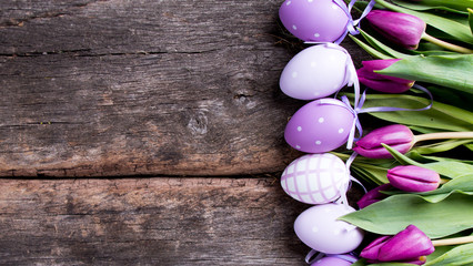 Easter eggs and flower on wooden table. Spring concept on plank.