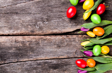 Easter eggs and flower on wooden table. Spring concept on plank.