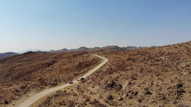 4x4 offroad vehicle driving up very steep Spreetshoogte Pass of central Namibia Khomas highland area close to Sossusvlei, Aerial drone shot