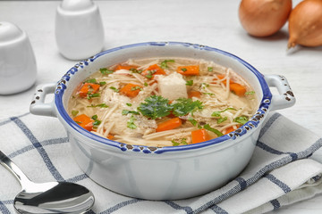 Dish with fresh homemade chicken soup served on table