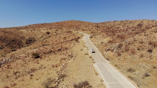 4x4 offroad vehicle driving up very steep Spreetshoogte Pass of central Namibia Khomas highland area close to Sossusvlei, Aerial drone shot