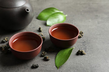 Composition with brewed Tie Guan Yin Oolong tea on grey table. Space for text