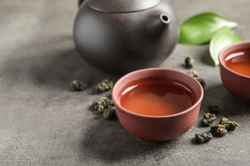 Composition with brewed Tie Guan Yin Oolong tea on grey table. Space for text