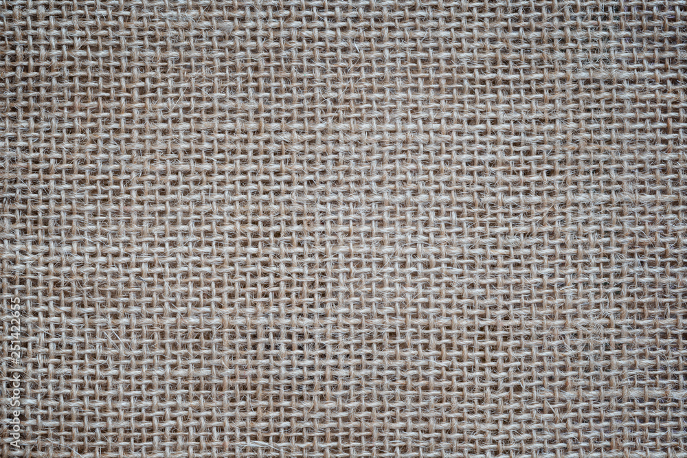Poster close-up of a burlap jute canvas full frame background with vignetting.