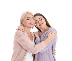 Portrait of young woman with her mature mother on white background
