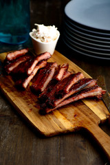 Smoked ribs ready to be eaten on wooden plate.​