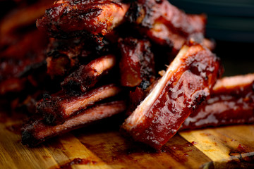 Smoked ribs ready to be eaten on wooden plate.​ - obrazy, fototapety, plakaty