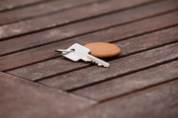 Hotel suite key with wooden fob for room on wood table. Room key on wood texture and background. Silver key with a blank label on an old wooden plank. Security and key in hand. Key of my success.