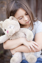 Little Girl Holding Ragged Teddybear Outside - Poverty, Homelessness