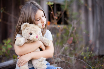 Little Girl Holding Ragged Teddybear Outside - Poverty, Homelessness