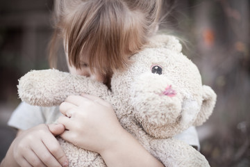 Little Girl Holding Ragged Teddybear Outside - Poverty, Homelessness