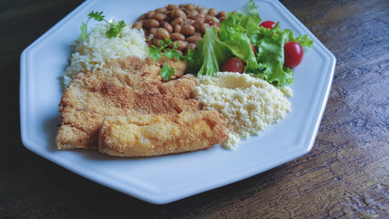 Dish of food - Fish, rice, beans, salad and flour.