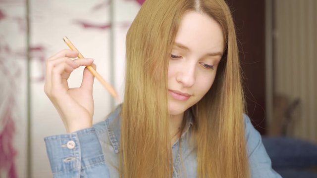 Close-up portrait of a beautiful excited woman drowing with pencils amd smiling 