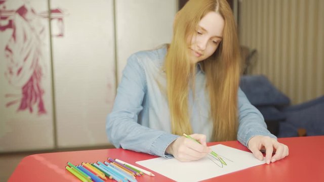 Close-up portrait of a beautiful excited woman drowing with pencils amd smiling 