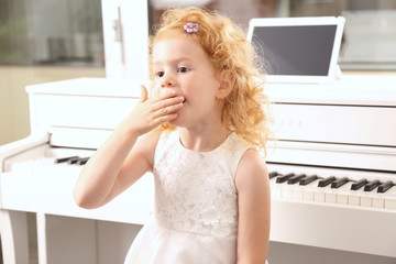 Mädchen gähnt überfordert beim Klavier lernen