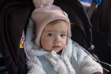 Small child sitting in car seat, safety for children