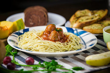 Spaghetti with meatballs in tomato sauce and fresh fruits