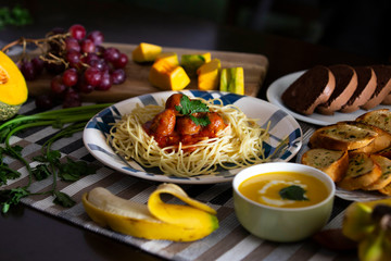 Spaghetti with meatballs in tomato sauce and fresh fruits