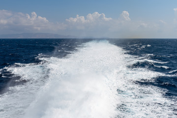 Water trail foaming behind a ferry boat in Aegean Sea. Greece. Vacation concept