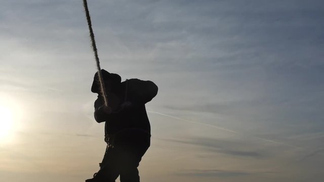 human in black hoodie pulling rope on wind silhouette front view