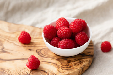 Fresh Raspberries In A Bowl On Wood and Linen Background