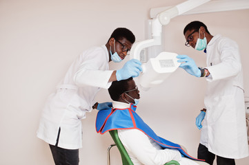 African american male doctors in professional uniform taking x-ray of patient.