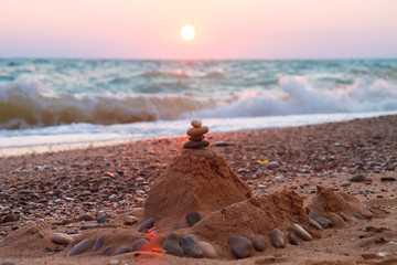 Figure of stones and sand against the setting sun.