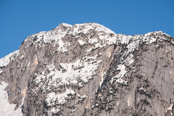 Snowy mountain peak Backenstein with summit cross on winter day