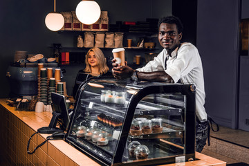 Two young multiracial baristas working at their trendy coffee shop.