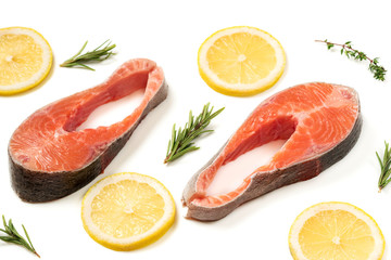 Steak of red fish, salmon with lemon, rosemary and thyme. Trout on white background.